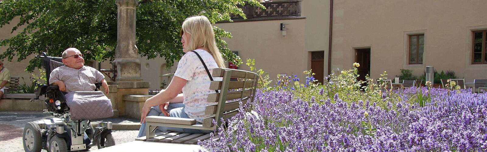 Gruppe mit Mann im Rollstuhl im Hof des Lutherhauses