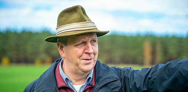 Bernd Moritz auf dem Feld, zeigt in die Ferne