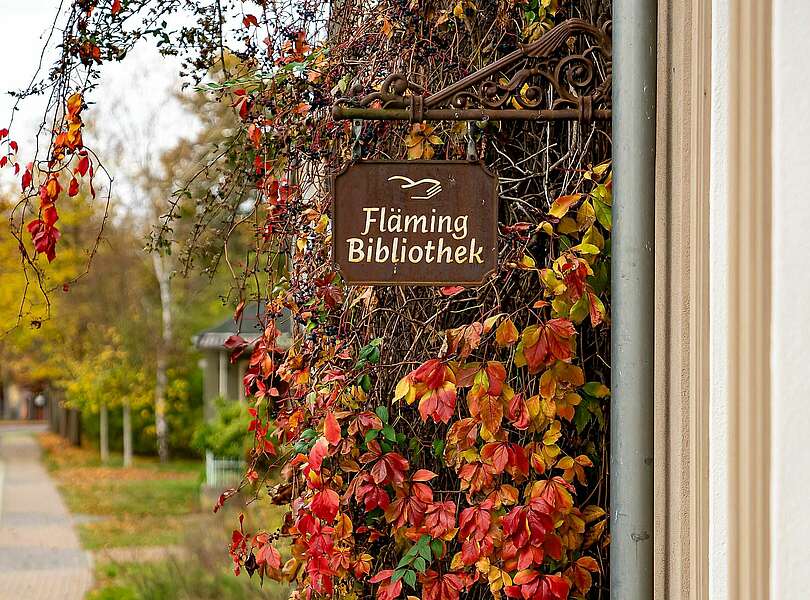 Schild der Fläming-Bibliothek am Gasthof Moritz